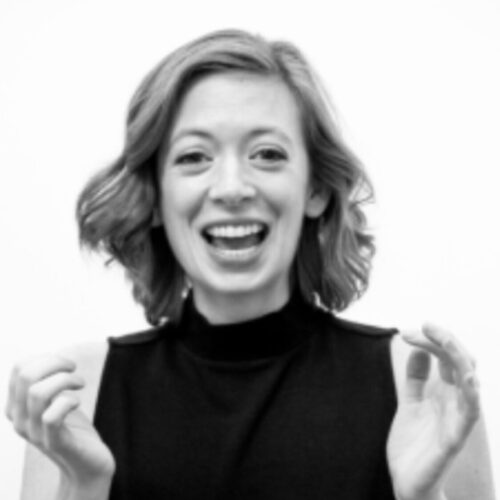 A woman in black shirt smiling for the camera.